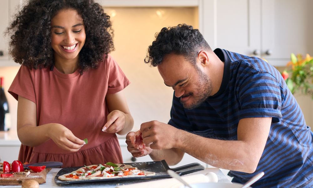 disabled man and cooking pizza with support worker 